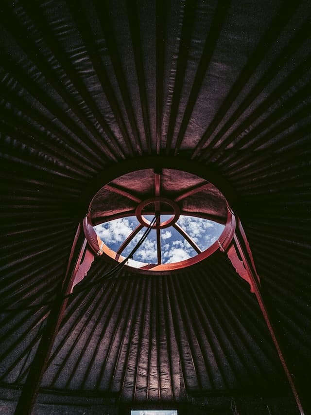 Looking up through the toono crown ring of a yurt — the same symbol as the Nomad Organizing mark